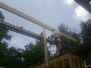 Carpenter setting a ridge beam over a new addition frame — Ice Dam Removal by Roofing Brothers in Callahan
